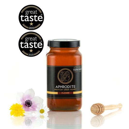 Greek Raw Flower / Blossom Honey in a 950g glass jar in white background. Jar presented from the front . 100% Pure Honey. Aphrodite Honey. Aphrodite Premium Greek Honey. Great Taste 1 star.