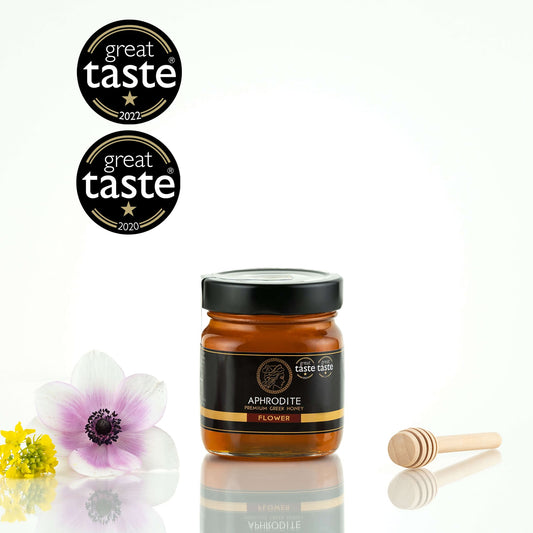 Greek Raw Flower / Blossom Honey in a 250g glass jar in white background. Jar presented from the front . 100% Pure Honey. Aphrodite Honey. Aphrodite Premium Greek Honey. Great Taste 1 star.
