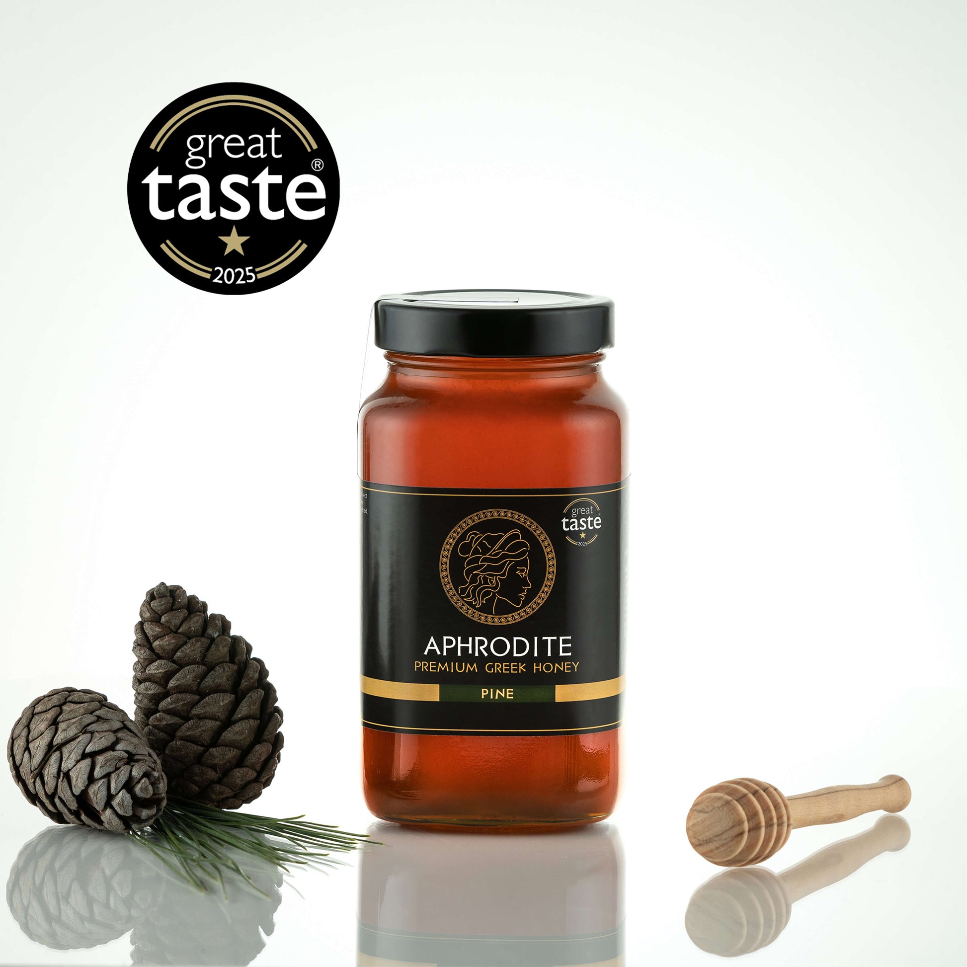 Aphrodite Raw Pine Honey 950g large jar with pinecones, a pine sprig and honey dipper, Great Taste 2025 award badge, white background