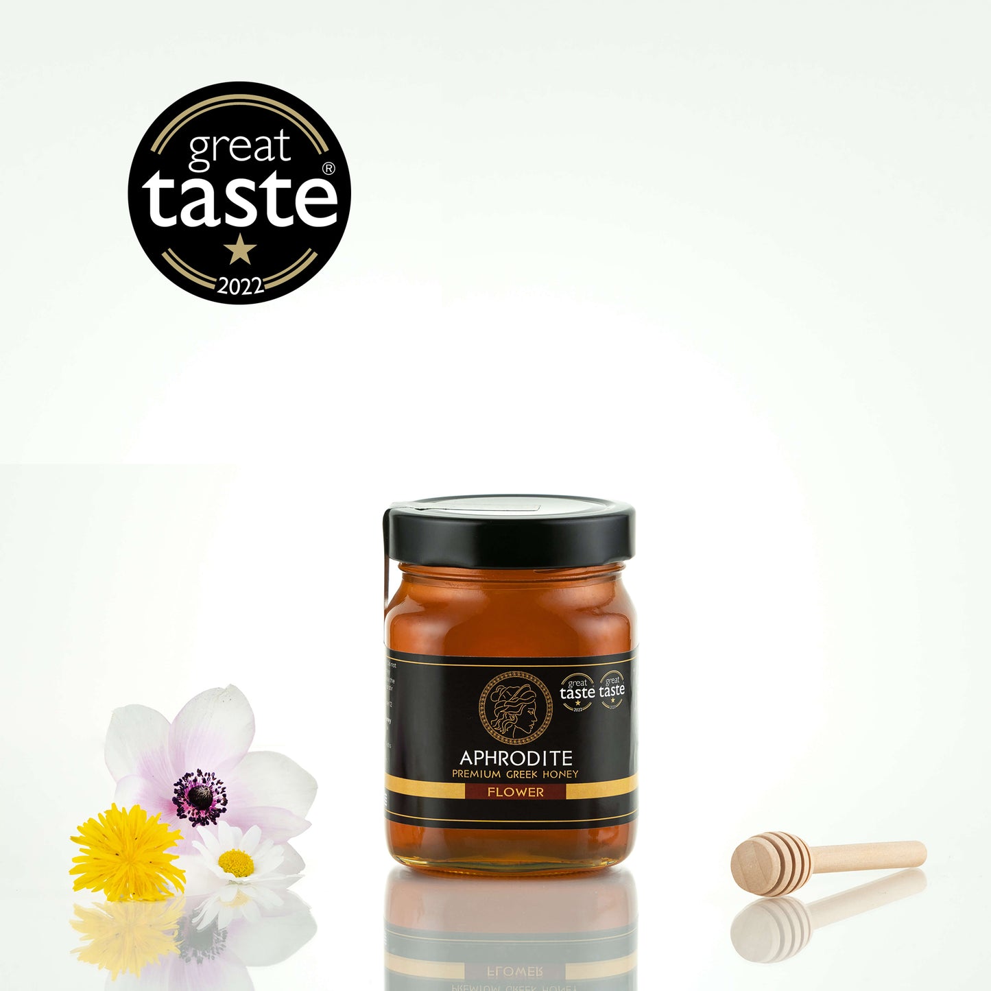 Aphrodite Raw Flower Honey 480g jar with white and yellow wildflowers and a honey dipper, Great Taste 2022 award badge, white background