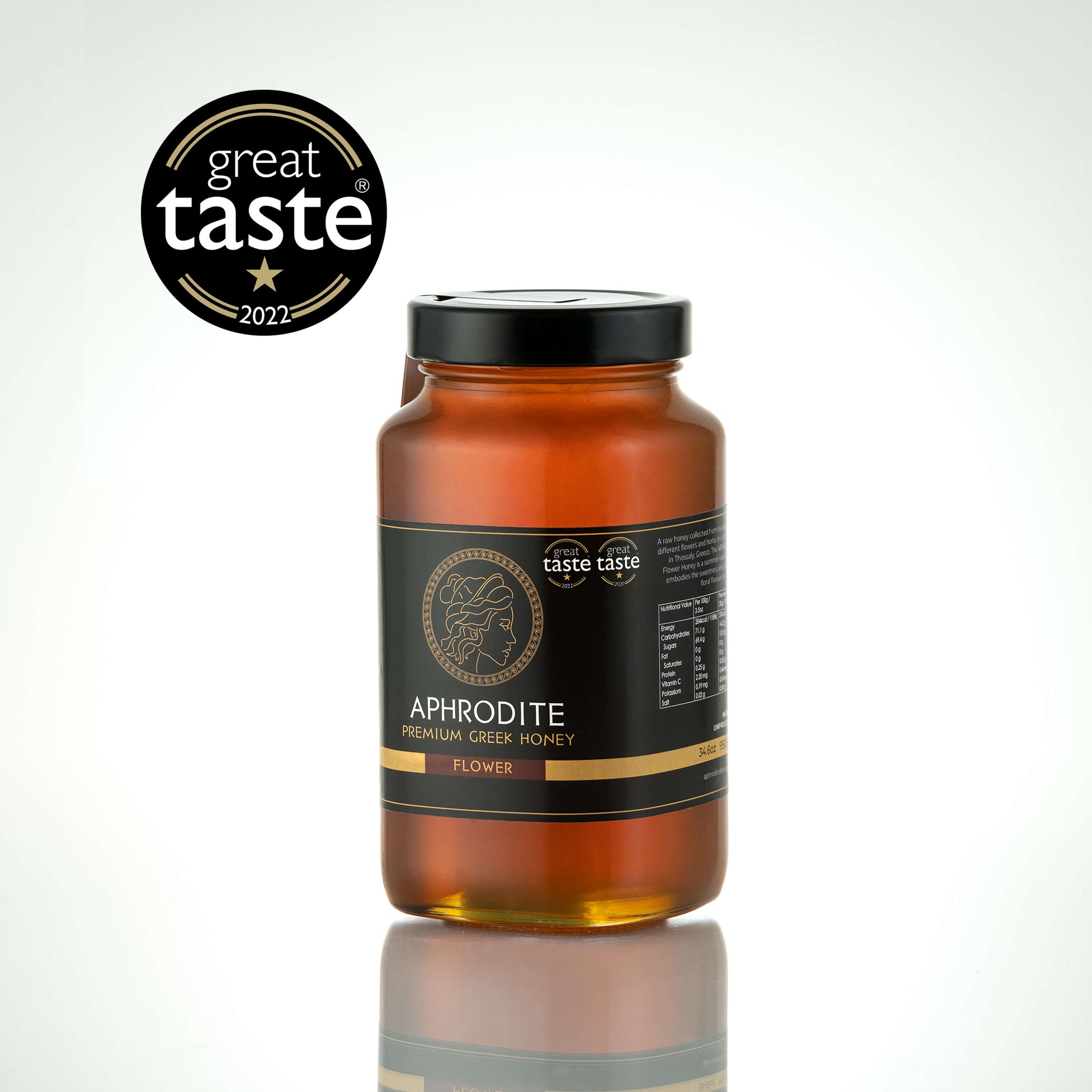 Aphrodite Raw Flower Honey 950g large glass jar with black lid on a white reflective background, Great Taste 2022 award badge