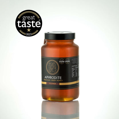 Aphrodite Raw Flower Honey 950g large glass jar with black lid on a white reflective background, Great Taste 2022 award badge